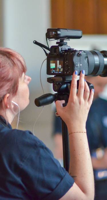 Une femme entrain de filmer et prendre des prises de vues pour la création de contenus uniques et sur-mesure